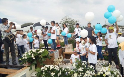 <p>Relatives and sympathizers release blue and white balloons as they send to his final resting place at the Cabatuan Cabatuan Catholic Cemetery in Brgy. Banguit Angelo Claveria, the Ilonggo overseas Filipino worker who was killed in South Korea on Friday, June 1, 2018 <em>(PNA Photo by Caihra Santillan)</em></p>